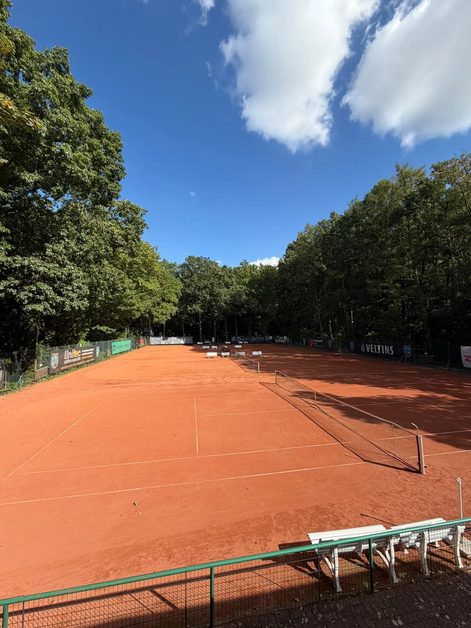 Sandplatz mit Netz und Bandenwerbung auf der Anlage am Naugardenring